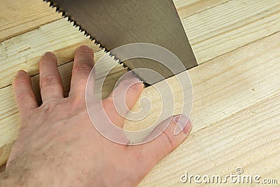 The man`s hand was caught under the blade of a hand saw, non-compliance with safety regulations Stock Photo