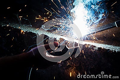 Man`s hand welding steel with sparks Stock Photo