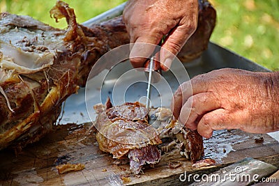 Cutting whole lamb baked on a spit Stock Photo