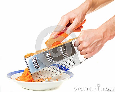 Man's hands grating carrots. Stock Photo