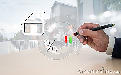 The man's pen is pointing to a home symbol on the versual screen. The notion of home loan payment and reduction, interest Stock Photo