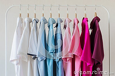 Man`s polo shirts hanging in row in rack Stock Photo