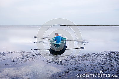 Man sailing on a small rowing boat along the sea coast Stock Photo