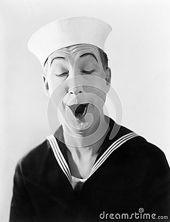 Man in sailor hat and uniform making a silly pantomime face Stock Photo