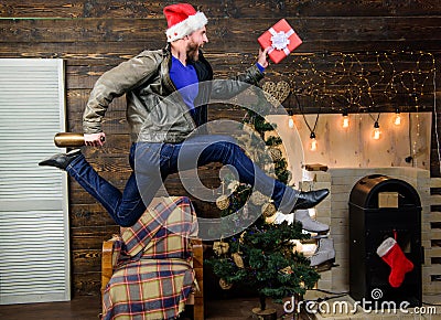 Man santa hat hurry to deliver gift on time. Christmas is coming. Spread happiness and joy. Bearded guy in motion jump Stock Photo