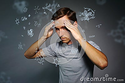 Man scientist thinking about chemical formulas on gray background. Stock Photo