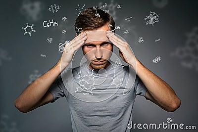 Man scientist thinking about chemical formulas on gray background. Stock Photo