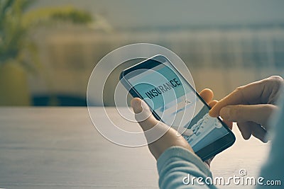 Man searching an insurance with his smartphone Stock Photo