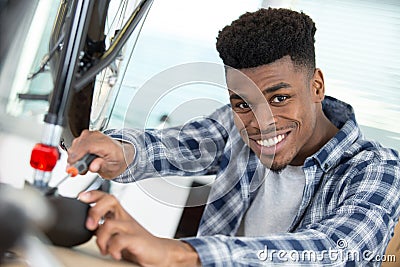 man securing bicycle seat with screwdriver Stock Photo