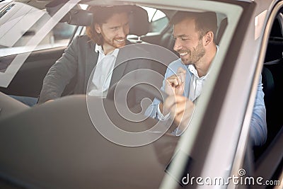 Man with seller sitting in new car Stock Photo