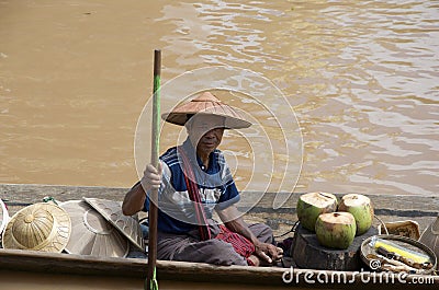 Man selling coconuts from canoe Editorial Stock Photo