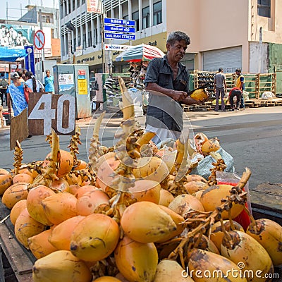 Man selling coconuts on the street in town Editorial Stock Photo