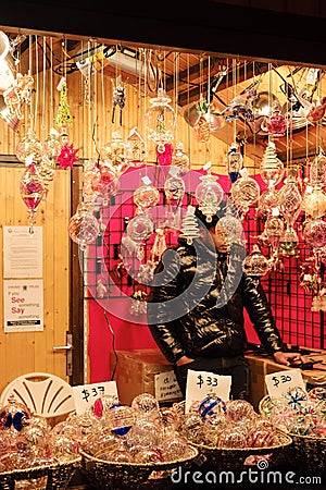 a man is selling gifts at an indoor christmas market area Editorial Stock Photo