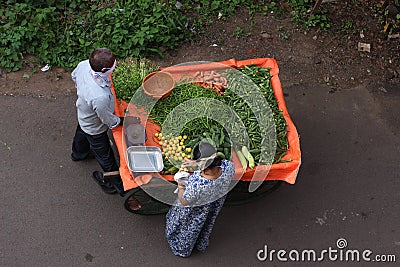 Man selling vegetables on the street and wearing a mask Editorial Stock Photo