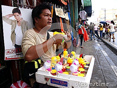 A man sells different kind of toys at a sidewalk Editorial Stock Photo