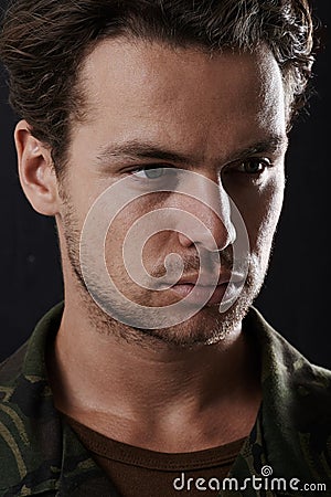 Man is serious in army uniform, soldier or hero in headshot with military service on black background. Face of warrior Stock Photo