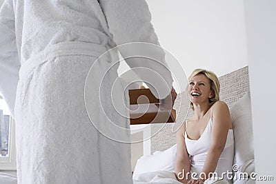 man serving breakfast to cheerful woman bed midsection men women 33888958 -