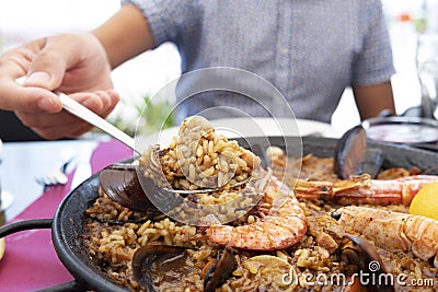 Man serving a typical spanish seafood paella Stock Photo