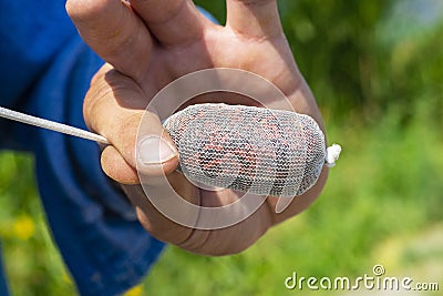 Man is setting up a pva bag full of food for carp. stick mix with sauce. Carp fishing rigs Stock Photo