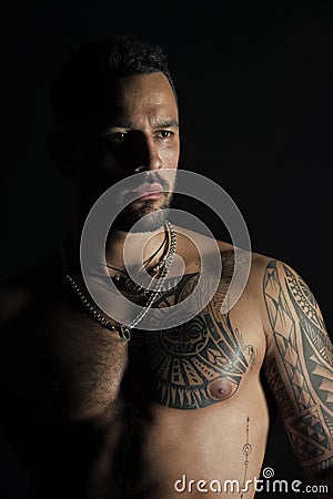 Man with sexy muscular torso. Bearded man with tattooed chest. Fit model with tattoo design on skin. Sportsman or Stock Photo