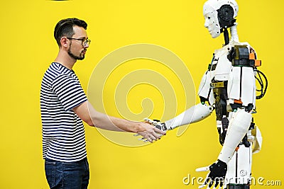 A man shakes hands with a robot close-up. engineer to create a robot. future robotics concept Stock Photo