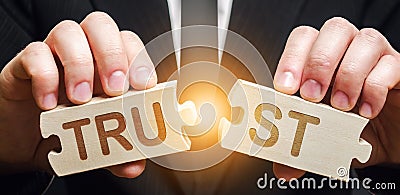 A man shares two puzzles with the word Trust. Violation of agreements and promises. Lose credibility. Failed to maintain Stock Photo