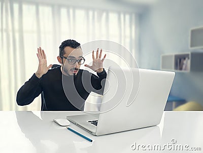 Man Shocked Reading Message on Computer in Office Stock Photo