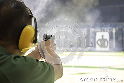 Man shooting automatic pistol to target in shooting range Stock Photo