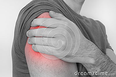 Man with shoulder pain is holding his aching arm Stock Photo