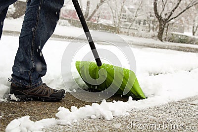 Man shoveling and removing snow in front of his house in the suburb Stock Photo