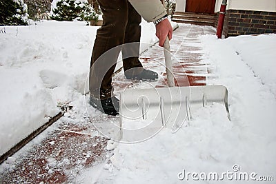 Man shoveling snow at a footpath Stock Photo