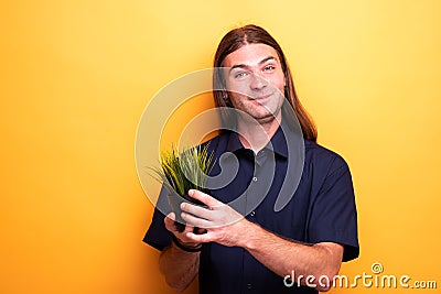 Man showing apartment plant in a pot Stock Photo
