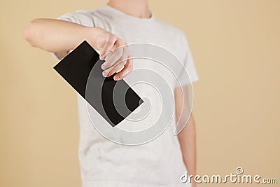 Man showing aslant blank black flyer brochure booklet. Leaflet p Stock Photo