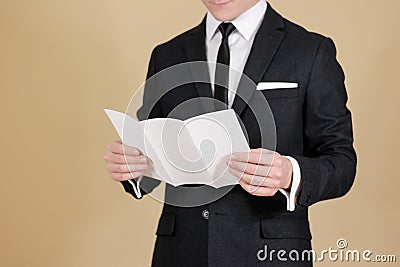 Man showing blank black flyer brochure. Read detailed booklet. L Stock Photo