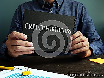 The man shows an sign Creditworthiness on a black page. Stock Photo