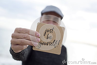 Man shows signboard with the text just be yourself Stock Photo