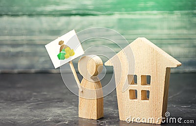 A man with a sign at the house. House sale. The appraiser appraises the property. Home purchase, invest in real estate. Favorable Stock Photo