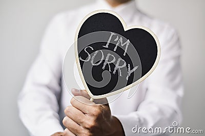 Man with a signboard with the text I am sorry Stock Photo