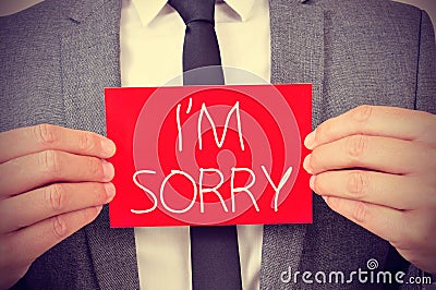 Man with signboard with the text I am sorry Stock Photo