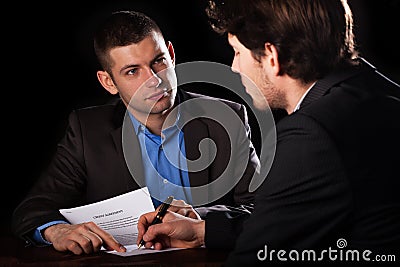 Man signing a loan with a lawyaer Stock Photo