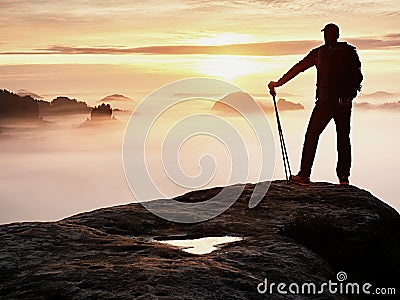Man silhouette stay on sharp rock peak. Satisfy hiker enjoy view. Tall man on rocky cliff Stock Photo