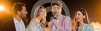 Man singing while in microphone near Stock Photo