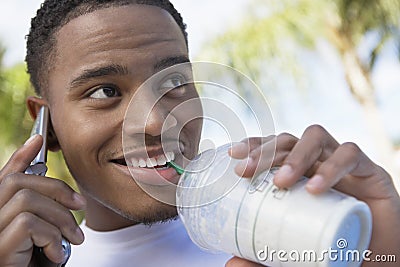 Man Sipping Milkshake While On Call Stock Photo
