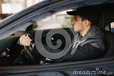 Man sit in the car. Handsome young man driving a car Stock Photo