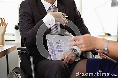 Man sit in wheelchair and holds statistical report Stock Photo