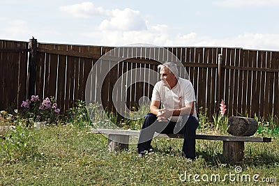 Man sits on bench Stock Photo