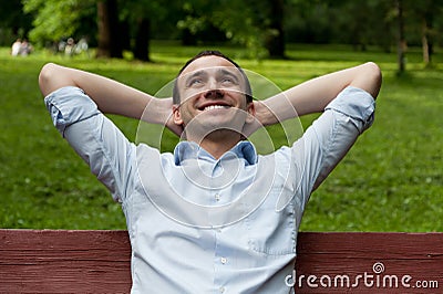 Man sits on bench Stock Photo