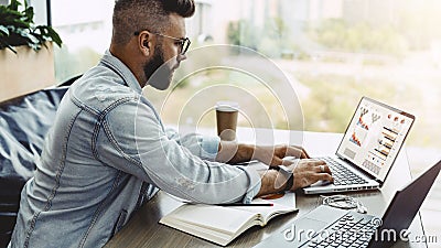 Man sits in cafe, works on laptop with charts, graphs on screen. Businessman is planning business.Online marketing Stock Photo