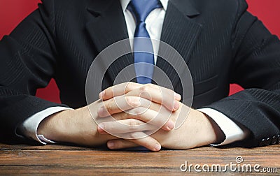 A man sits at the table with folded arms. Ready to listen to news and criticism. Serious talk. Calmly Stock Photo