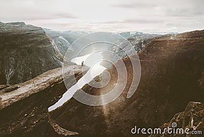 Man sitting alone on Trolltunga cliff edge in Norway Stock Photo